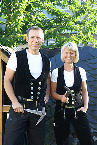 Das Bild zeigt eine Frau und einen Mann in Dachdecker Kluft